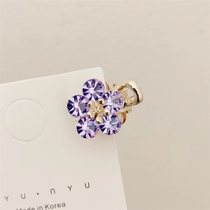 Mini molletta per capelli a fiore dorato con cristalli viola su carta bianca
