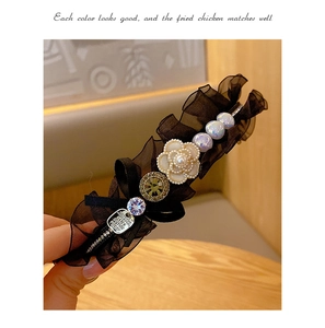 Detail of vintage black organza headband with pearl camellia flowers and sparkling rhinestones