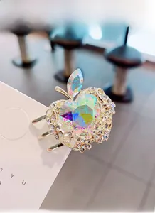 Detalle de una pinza de pelo con forma de manzana dorada, cristal de colores y diamantes