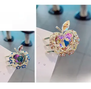 Detalle de pinzas para el cabello de aleación con forma de manzana y cristales de corazón