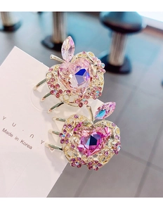 Detalle de pinzas para el pelo de manzana de cristal rosa con pedrería de corazón
