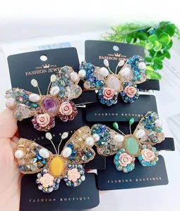 Lot de quatre barrettes papillon avec cristaux et perles colorées sur carte