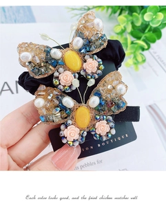 Détail de la pince à cheveux papillon faite main avec perles et cristaux colorés