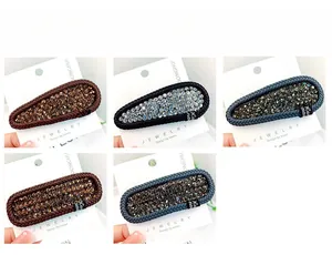 Detailed close-up of woven leather BB clips with rhinestones and handmade labels