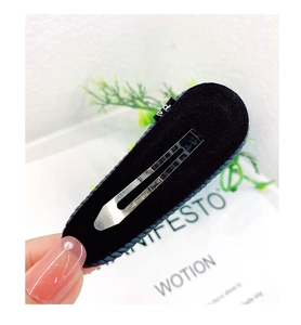 Detail view of a black velvet teardrop hair clip with a sturdy silver metal snap closure