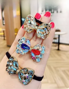 Détail de trois chouchous en forme de nœud avec strass brillants et élastiques noirs