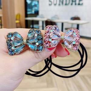 Vue détaillée de chouchous à nœuds en strass aux finitions bleu marine et rose clair