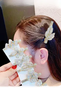 Detailansicht funkelnder goldener Haarklammern mit Zirkon-Blumen- und Blattmotiven