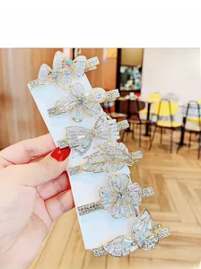 Detailansicht von sechs goldfarbenen Kristall-Haarspangen mit Blumen- und Schmetterlingsmotiv
