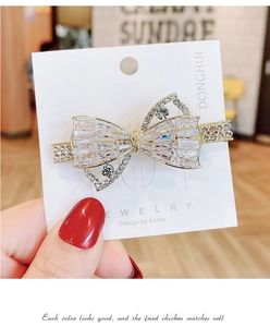 Detail einer glitzernden Schleifen-Haarspange mit Kristallen auf einer Karte