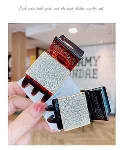Detail view of Korean acrylic claw clips with sparkling square rhinestones in amber and black
