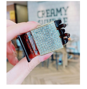 Detail of a large acrylic hair claw with a crystal square inlay and tortoiseshell texture