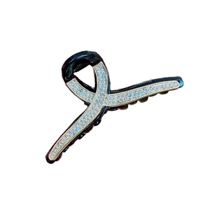 Elegant black hair claw clip with golden trim and sparkling rhinestone pavé design