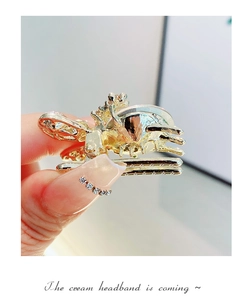 Close-up of golden metal hair claw with sparkling rhinestones and crystal rabbit details