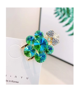 Detailed macro view of grape hair clip with gradient green crystals and gold butterfly