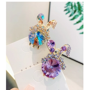 Close-up of rabbit hair clips with blue and purple crystals on elegant display card