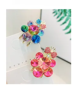 Detailed view of rhinestone grape hair clips with crystal petals and metal bow accents