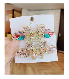 Gros plan de barrettes papillon fait main avec cristaux colorés sur base en alliage doré