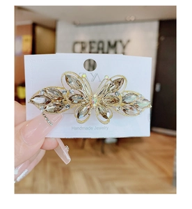 Vue macro détaillée de la pince à cheveux papillon dorée de 6 cm avec cristaux de champagne