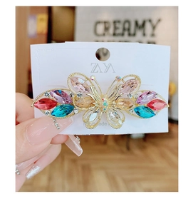 Détail d'une pince à cheveux papillon faite main avec des cristaux multicolores
