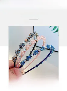 Détail de trois serre-têtes à fleurs en cristal en gris, rose et bleu royal élégants