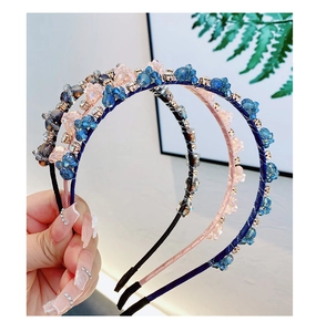 Détail d'un serre-tête fin en cristal avec perles bleues et roses et strass brillants