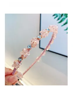 Gros plan d'un serre-tête rose en perles de cristal et strass aux tons doux et élégants