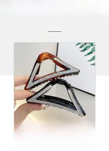 Detailed view of amber and black triangle hair claws with sparkling rhinestones decoration