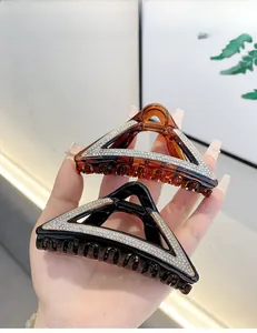 Detail showing two large triangle hair claws in black and amber with sparkling rhinestones