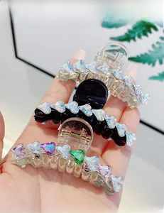 Dettaglio degli strass colorati a forma di cuore su fermagli per capelli trasparenti