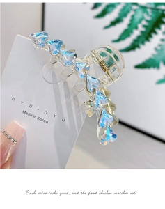 Dettaglio dei cristalli a cuore blu aurora e molla dorata sulla pinza per capelli