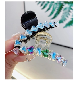 Dettaglio della clip per capelli a cuore con strass colorati e molla metallica robusta