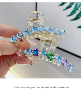 Macro di una grande clip per capelli in acrilico con strass colorati e molla dorata