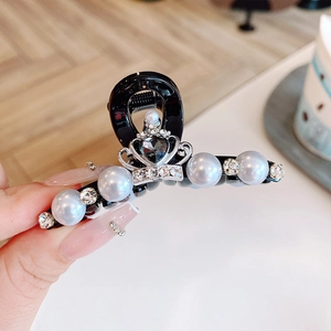Gros plan d'une pince à cheveux couronne avec perles et pierre grise en cœur
