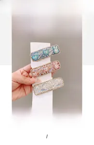 Detail of Korean BB hair clips with pearls, crystals, and heart motifs in three colors