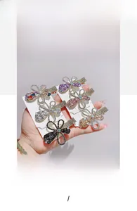 Set of five floral rhinestone hair clips in purple, pink, champagne, white, and black colors
