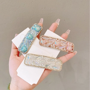 Detail of three rectangular BB clips with hearts, pearls and crystals in soft pastel colors