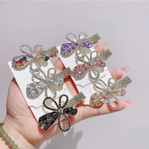 Floral rhinestone hair clips set in purple and pink tones on a display card