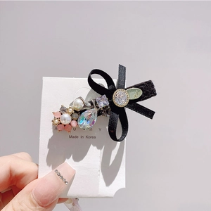 Detail of Korean style crystal hair clip with black silk bow, pearls, and rhinestones