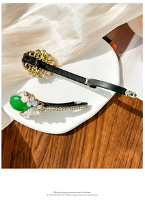 Close-up of emerald gemstone hair clips with pearls and rhinestones on a ceramic plate