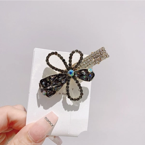 Detail view of flower hair clip with black gemstones and sparkling white crystals