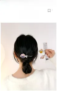 Détail de la pince à cheveux dorée avec fleurs en résine rose et perles de nacre