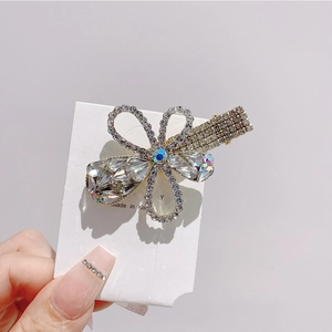 Macro shot of sparkling rhinestone flower hair clip with crystal accents and gold alloy base