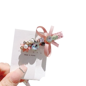 Pink satin bow hair clip with sparkling crystals and imitation pearls on card