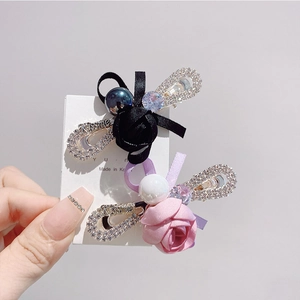 Détail de barrettes à fleurs en ruban de soie avec perles et strass sur carte blanche