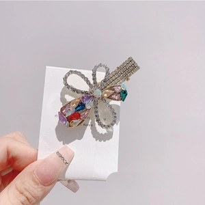 Detailed close-up of a floral hair clip featuring colorful rhinestones and alloy base