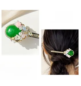 Detail of emerald gemstone hair clip with pearls and floral crystal decorations