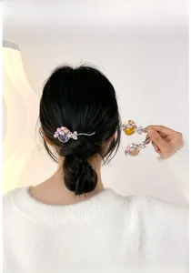 Détail de barrettes élégantes avec perles et feuilles sur une queue de cheval basse de mannequin