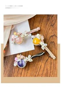Détail de pinces à cheveux en œil de chat avec perles et strass sur table en bois