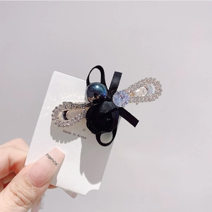 Gros plan détaillé d'une barrette à nœud en ruban de satin noir avec perles et cristaux